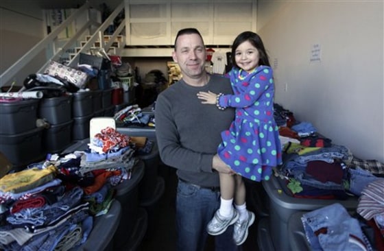 Terry Blackburn and his adopted daughter Jordan, a former foster child, stand among donated items at Jordan's Place, a not-for-profit in Brownsburg, Ind., founded by Blackburn and his wife. The Blackburns feel the state's proposed cuts to child services are too severe.